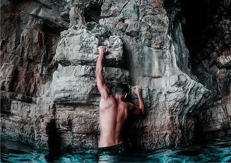 A photograph of a person exploring a waterfall.